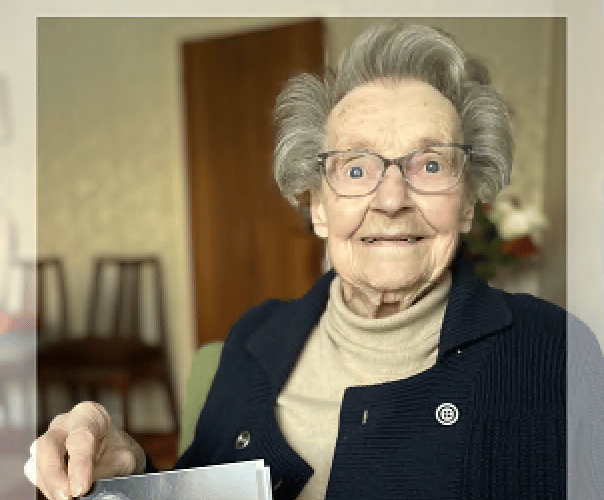 Iris Webb with her 100th birthday card from the King and a photograph of her as a young woman