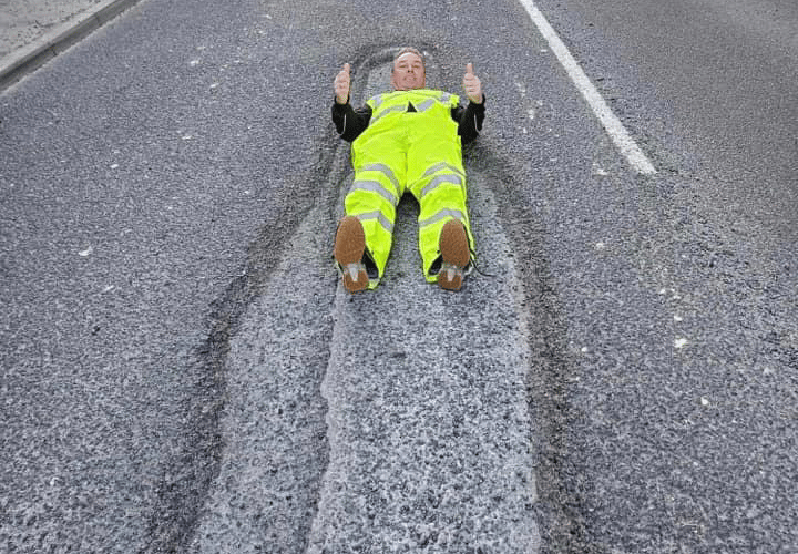 David Newcombe's lie-down protest to highlight the huge pothole on Tavistock's Plymouth Road.