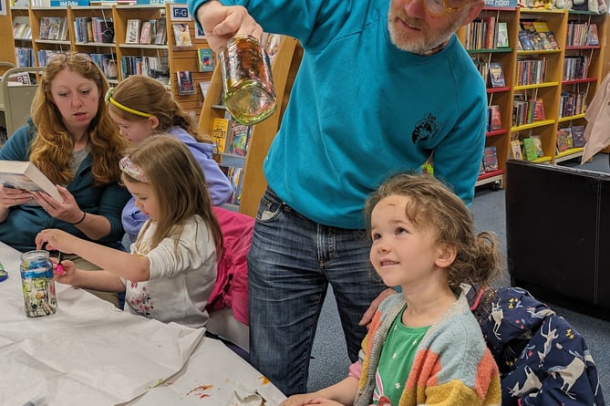 Glass painting at Tavistock Library to encourage less use of plastic packaging .