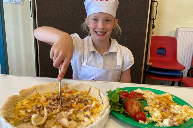 Charlotte slicing her quiche at Princetown School bake-off competition.