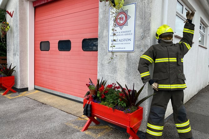 A village fire fighter scarecrow supporting Bere in Bloom.