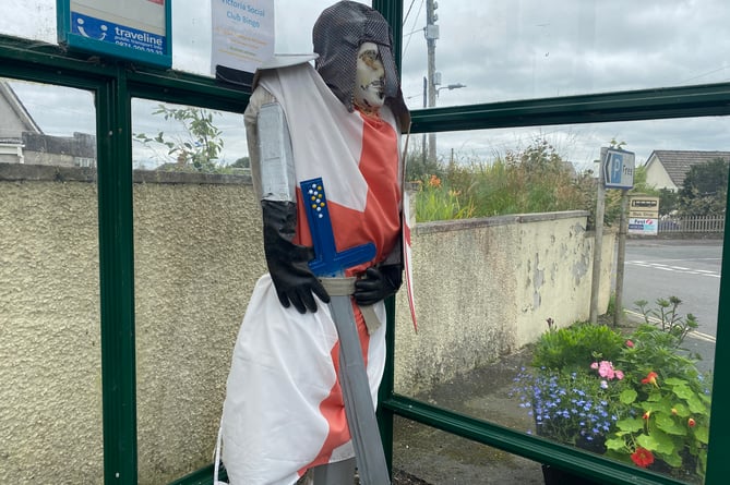 Crusading for floral success - a Bere in Bloom scarecrow knight in a village bus stop.