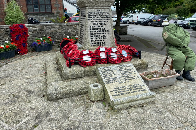 A military scarecrow keeps vigil at the village war memorial for Bere in Bloom.