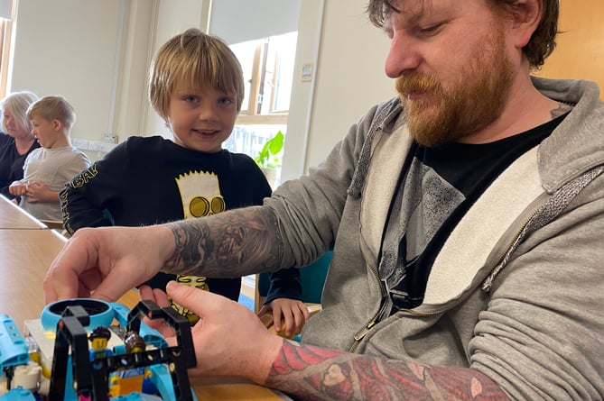 Simon Booker and his son Finn learning about Lego building and computer programming.