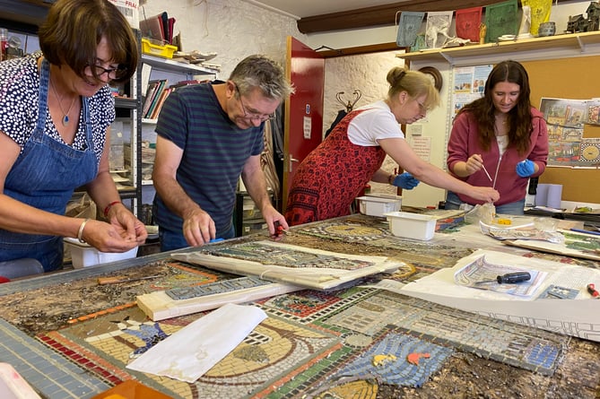 Volunteer crafters repairing a Tavistock community mosaic.