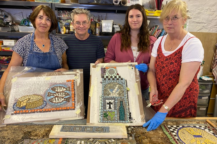 A Tavistock community mosaic undergoing painstaking repairs by volunteers L to R Christina Oldfield, Amy Ford and mum Jo Ford with professional Andy Carirns.