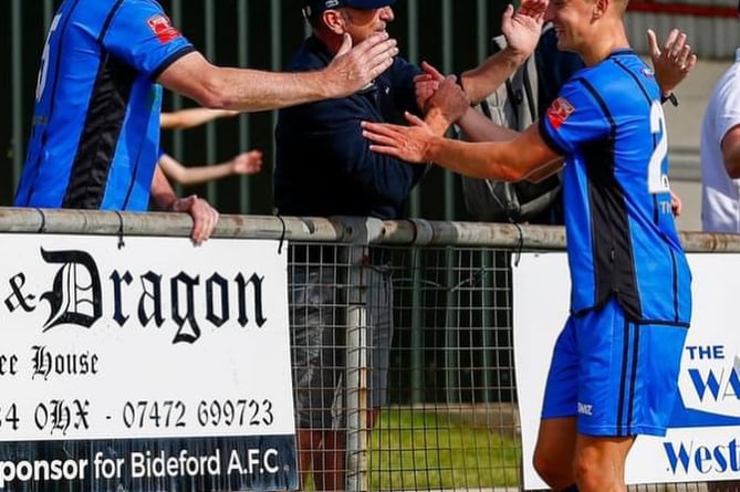 Tavi players celebrating with fans after Bideford win