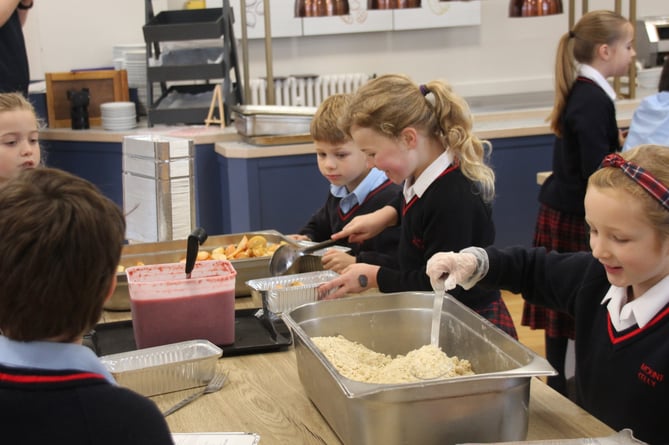 Young cooks from Mount Kelly College learning and providing food for those less well-off than themselves.