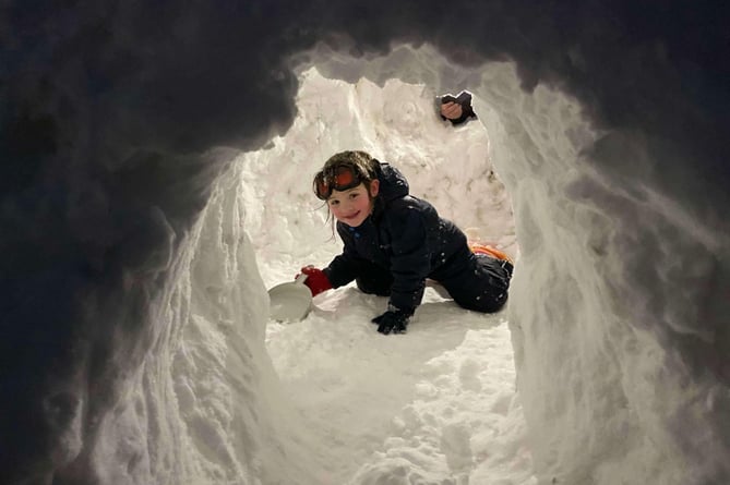 A little girl with the igloo she and a group  of children made at Princetown