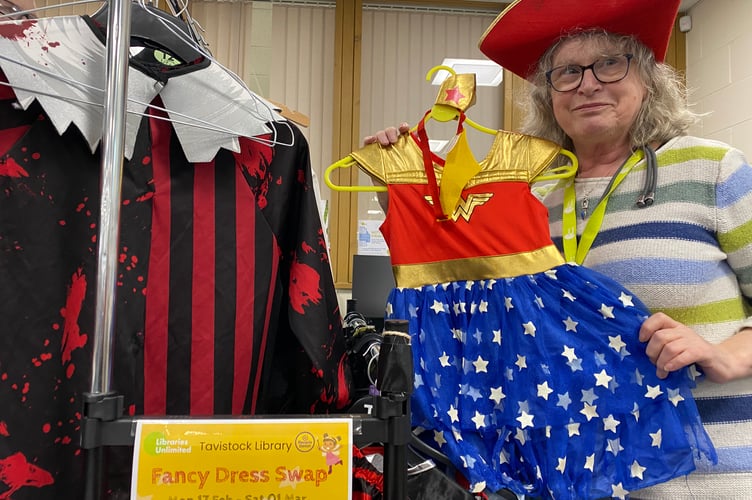 Denise Gatley demonstrating some of the donated costumes at Tavistock Library to help families join in World Book Day.