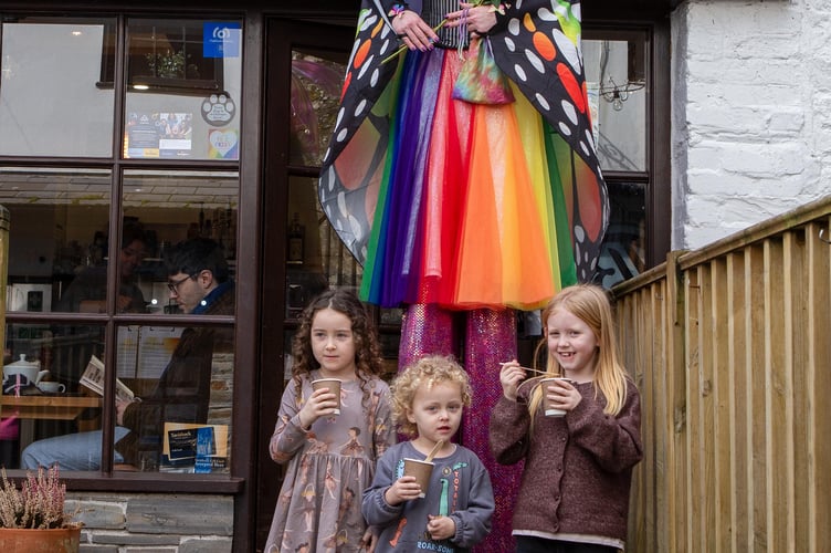 Children with their hot chocolate from Mime cafe, pictured with one of the fairy stiltwalkers.