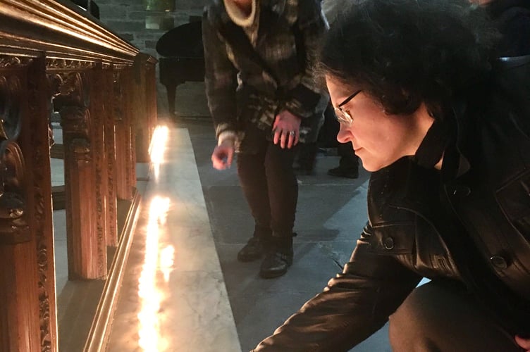 Nadia Pratt lights a candle at the service at St Eustachius' Church in Tavistock to mark three years since Russia's invasion of Ukraine