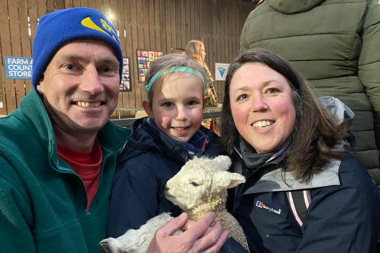 Katy, 4, making friends with a lamb at Greenwell Farm with parents Kirsty and Pete Davies.